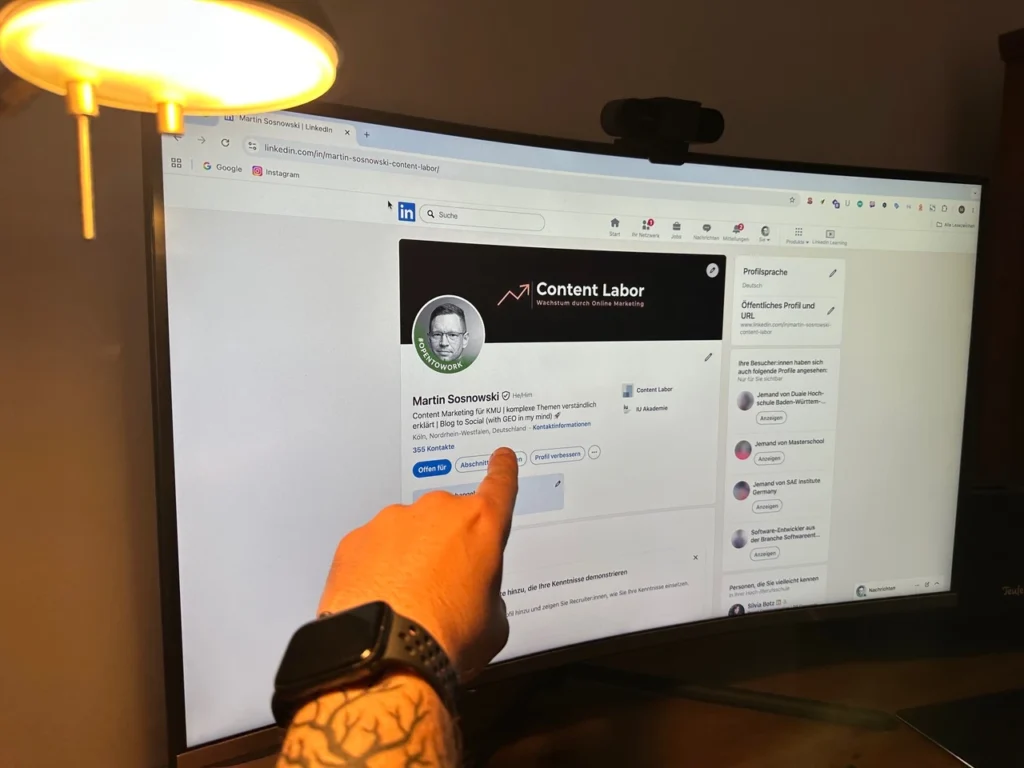 Das Bild zeigt Martins Arm, der auf den Monitor zeigt. Dort wird sein LinkedIn-Profil angezeigt.